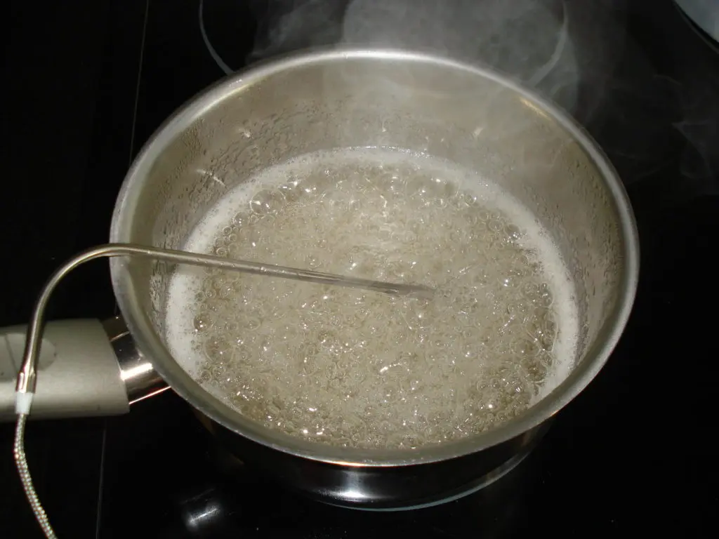 Selbstgemachter Kandissirup für belgische Biere wird in einem Stiltopf unter Temperaturkontrolle vorsichtig erhitzt
