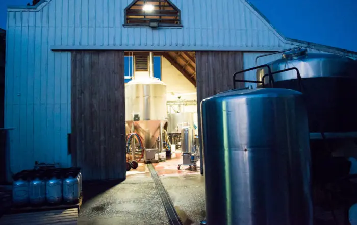 Andy Deuchars Micro-Brewery in Blenheim, Neuseeland, mit glänzenden Gärtanks und Brauanlage in einer Scheune.