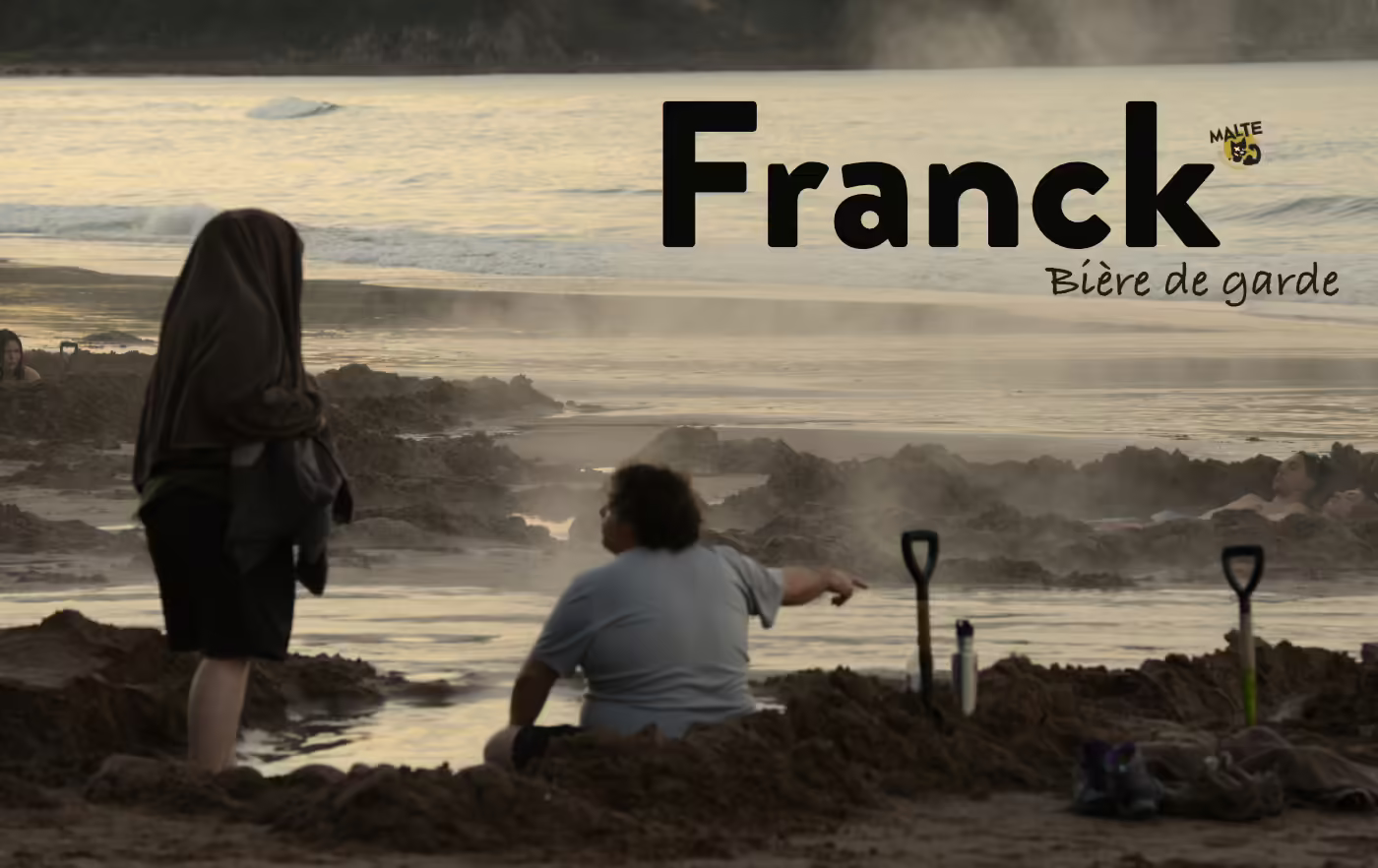Strandszene an der durch vulkanische Aktivität dampfenden Pazifikküste in Coromandel auf der Nordinsel Neuseelands, bei der ein dicker Mann Sandlöcher gebuddelt hat
