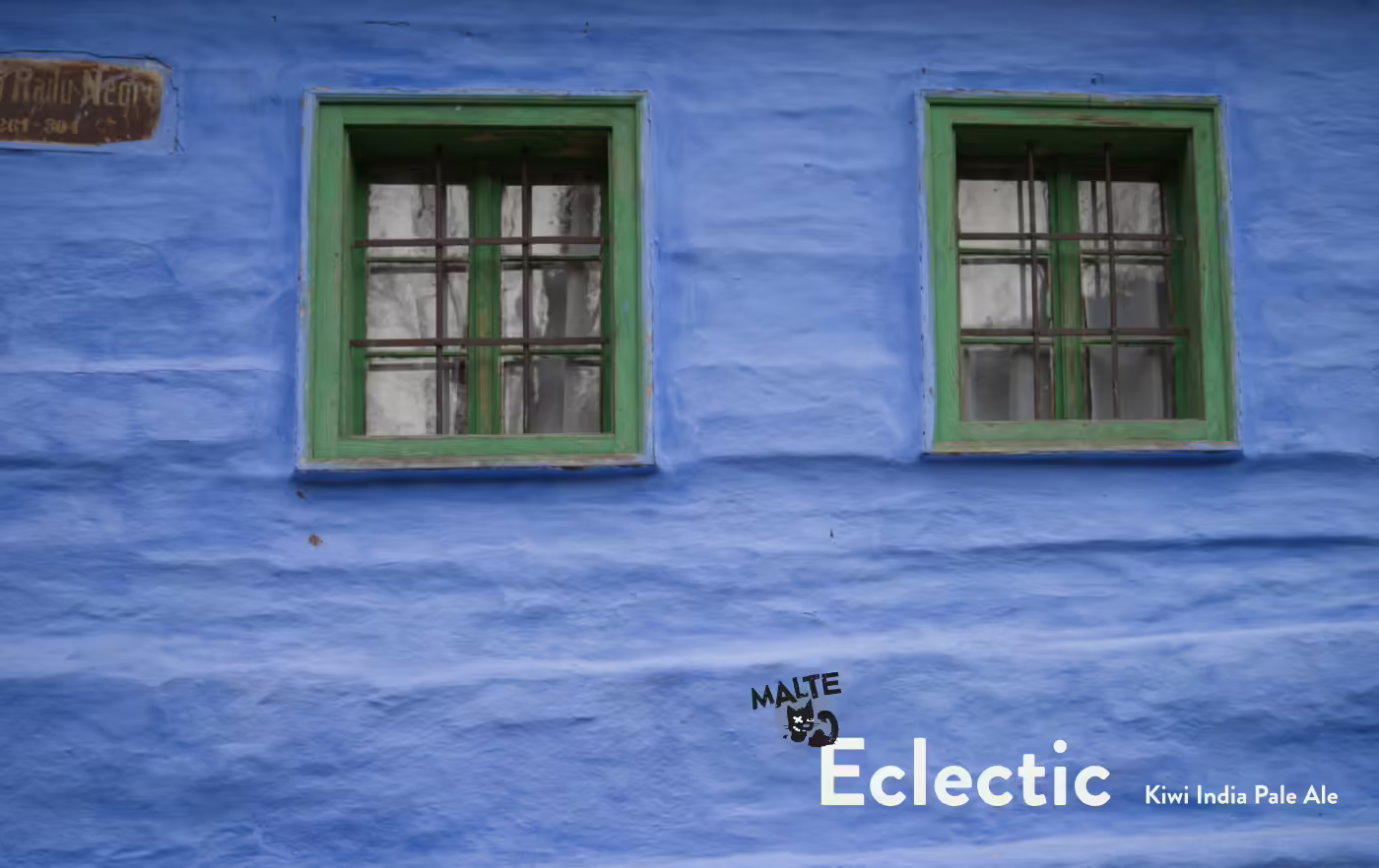 Französisch-blaue Hauswand mit grünen Fensterrahmen im rumänischen Dorf Sibiel