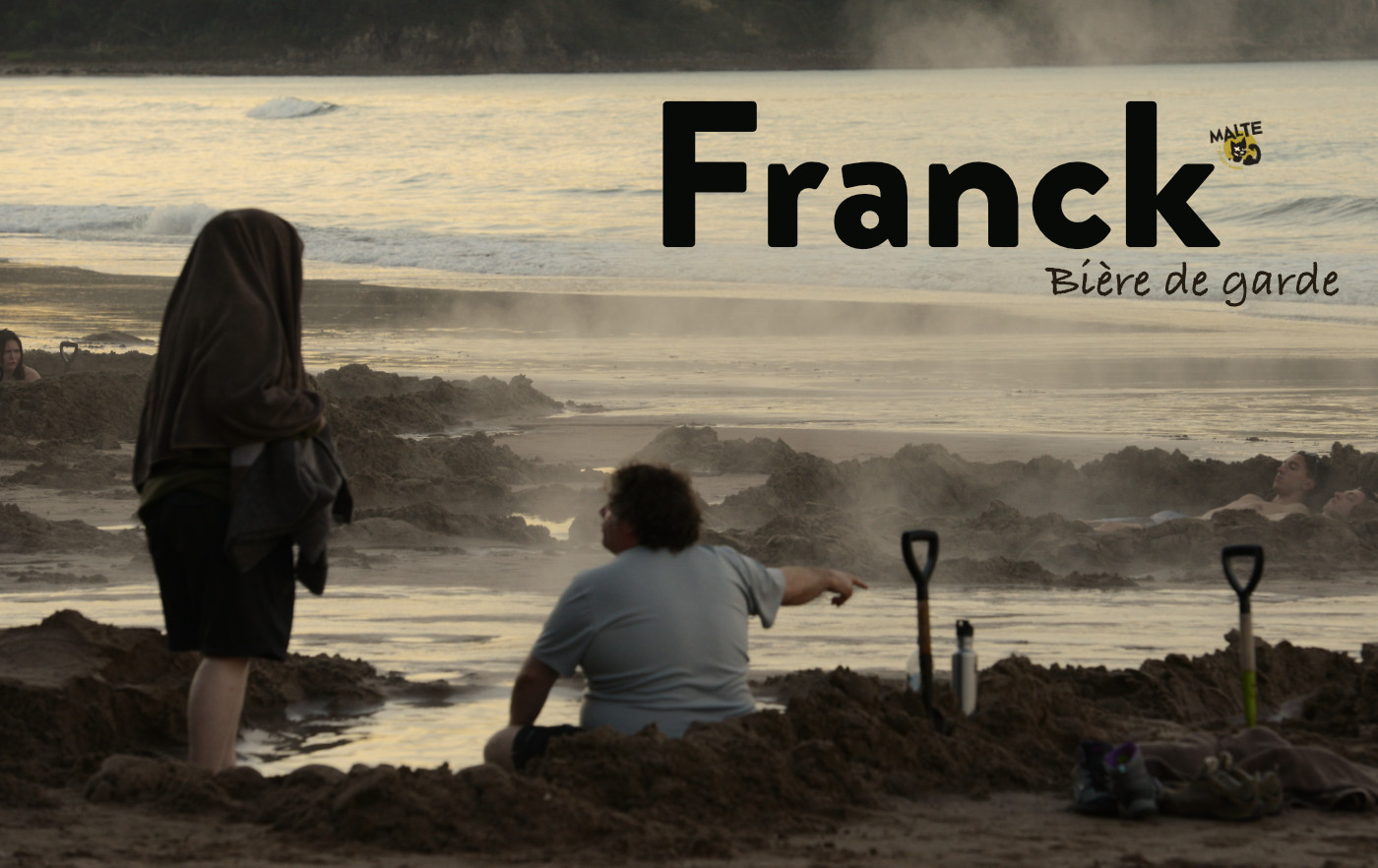 Strandszene an der durch vulkanische Aktivität dampfenden Pazifikküste in Coromandel auf der Nordinsel Neuseelands, bei der ein dicker Mann Sandlöcher gebuddelt hat